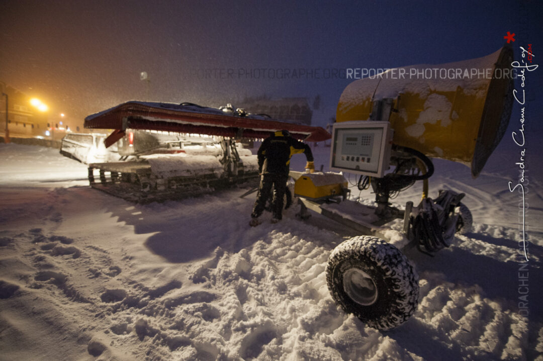 Pisteur secouriste attelant un canon à neige à une dameuse [Ref:2310-02-0338]